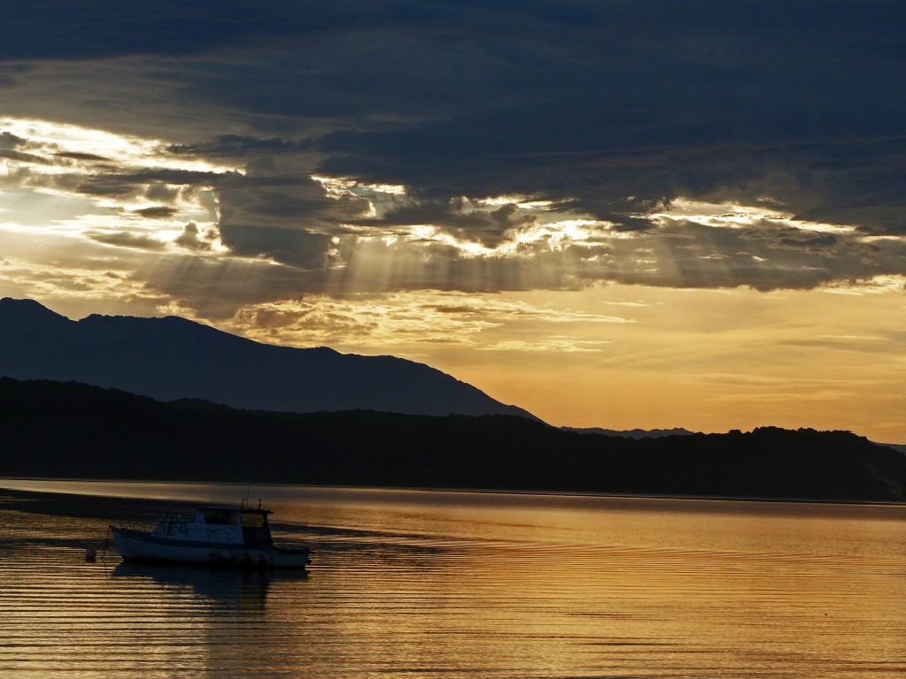 Sonnenaufgang mit Blick auf das Meer und einem ablegenden Fischerboot am Macquarie Heads Campground 